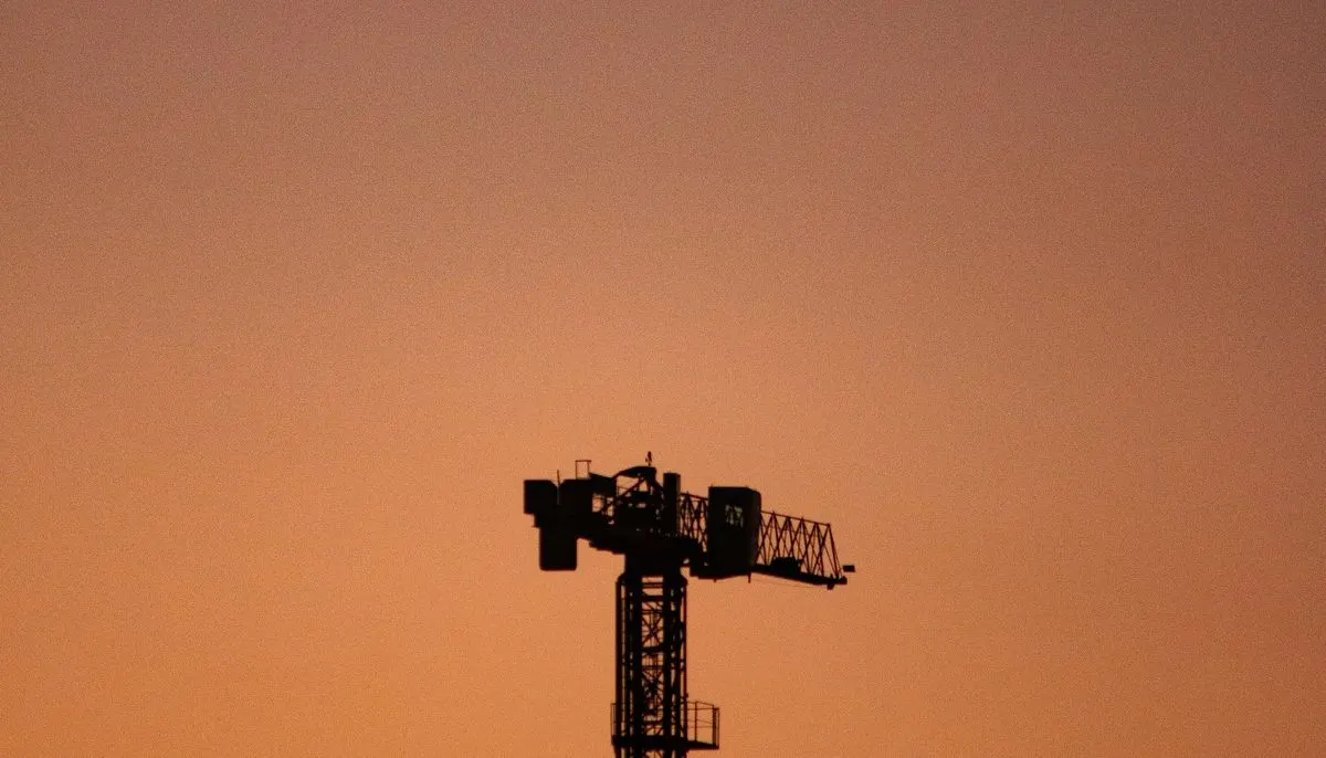 A silhouette of a tower crane