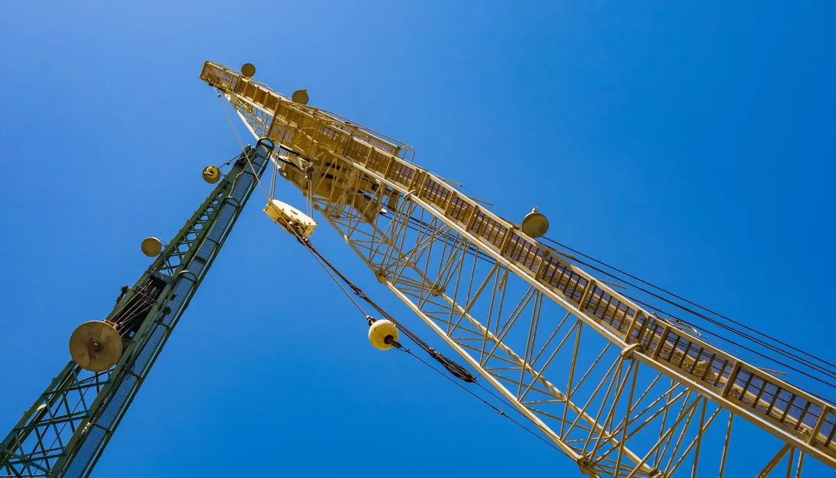 Low angle shot of two cranes under the blue sky