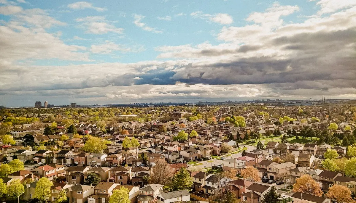 Aerial footage of a suburb with houses and clouds in the sky