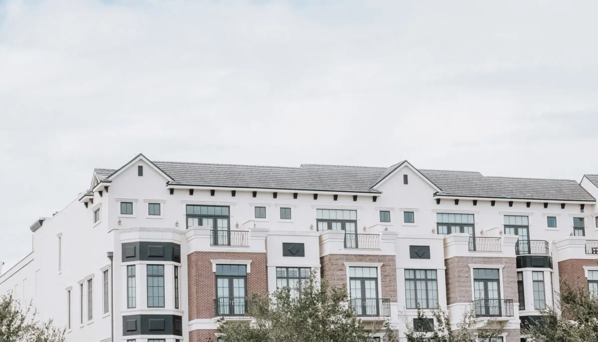 Facade of white apartment building under white sky
