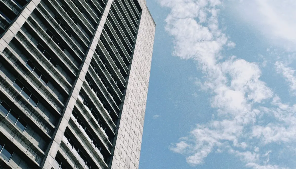 Fluffy white clouds over skyscraper
