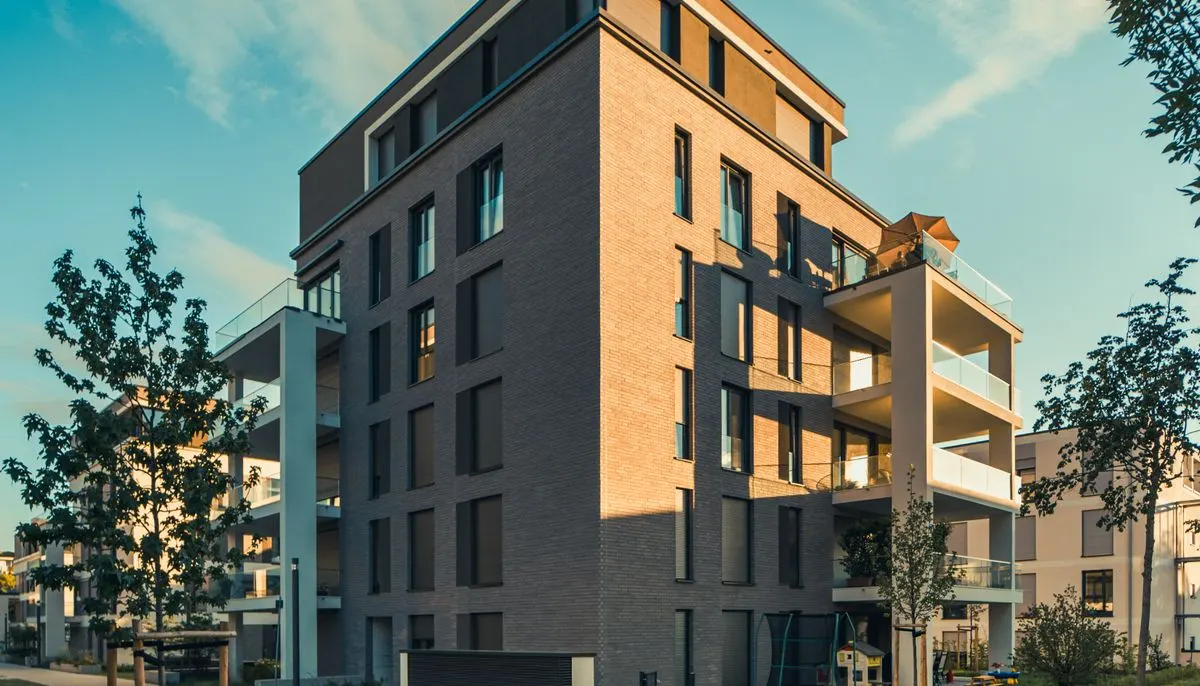 A modern apartment building with a green lawn