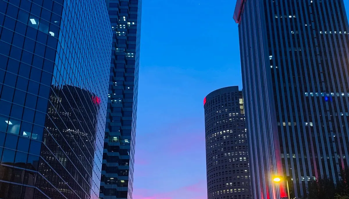 Glass skyscrapers beside empty road in evening