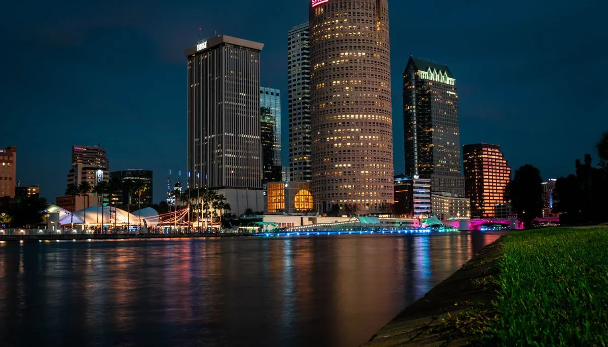 City skyline across body of water during night time