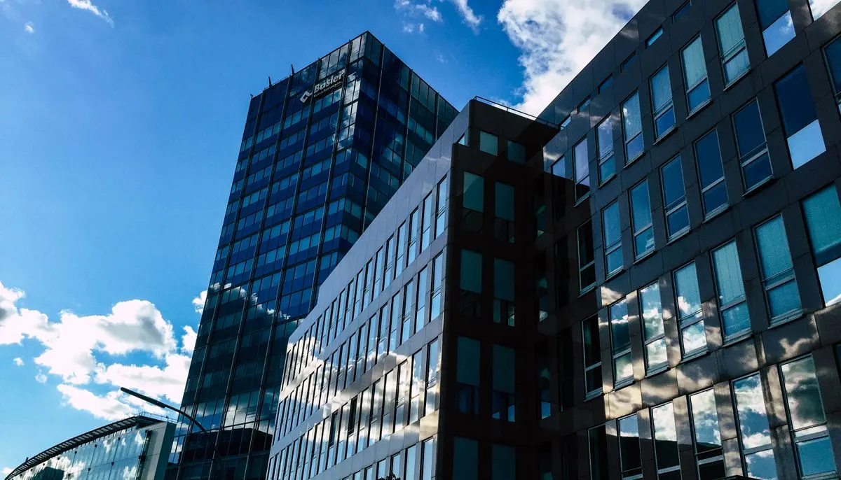 Low angle photography of curtain wall building taken under white clouds and blue sky